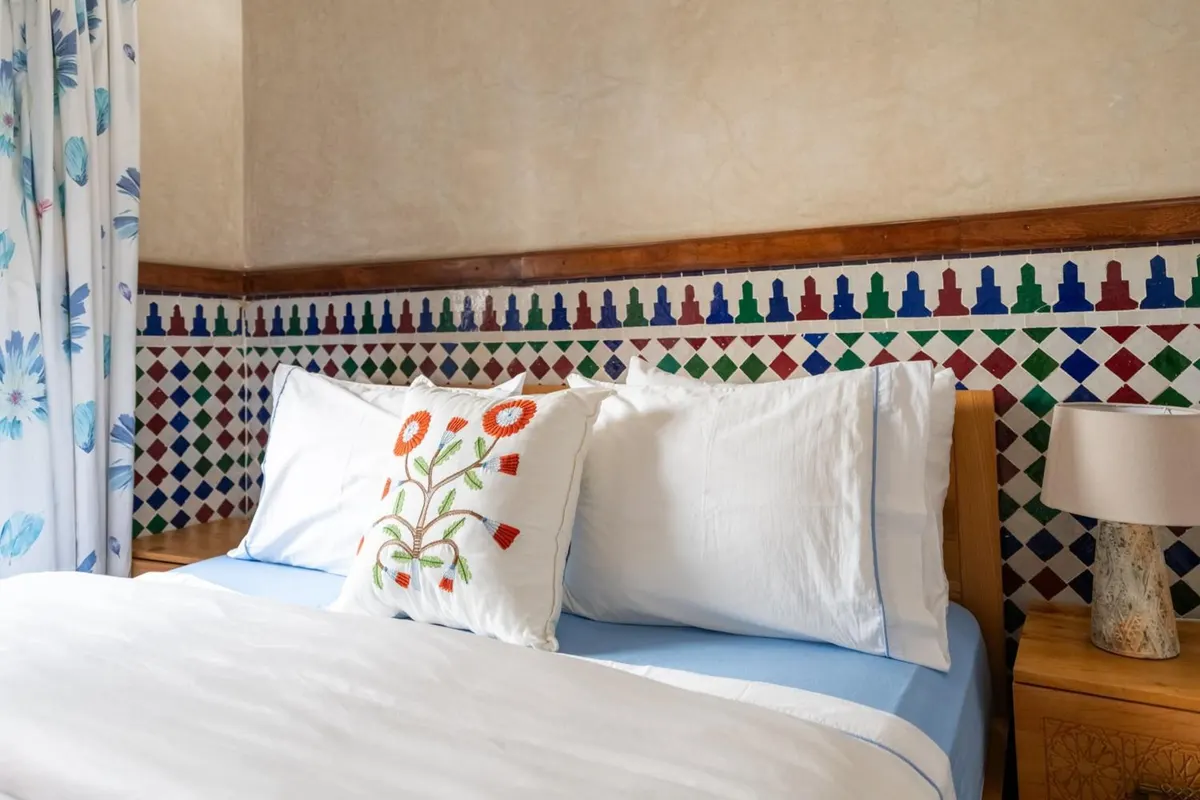 Embroidered cushion against a zellige wall