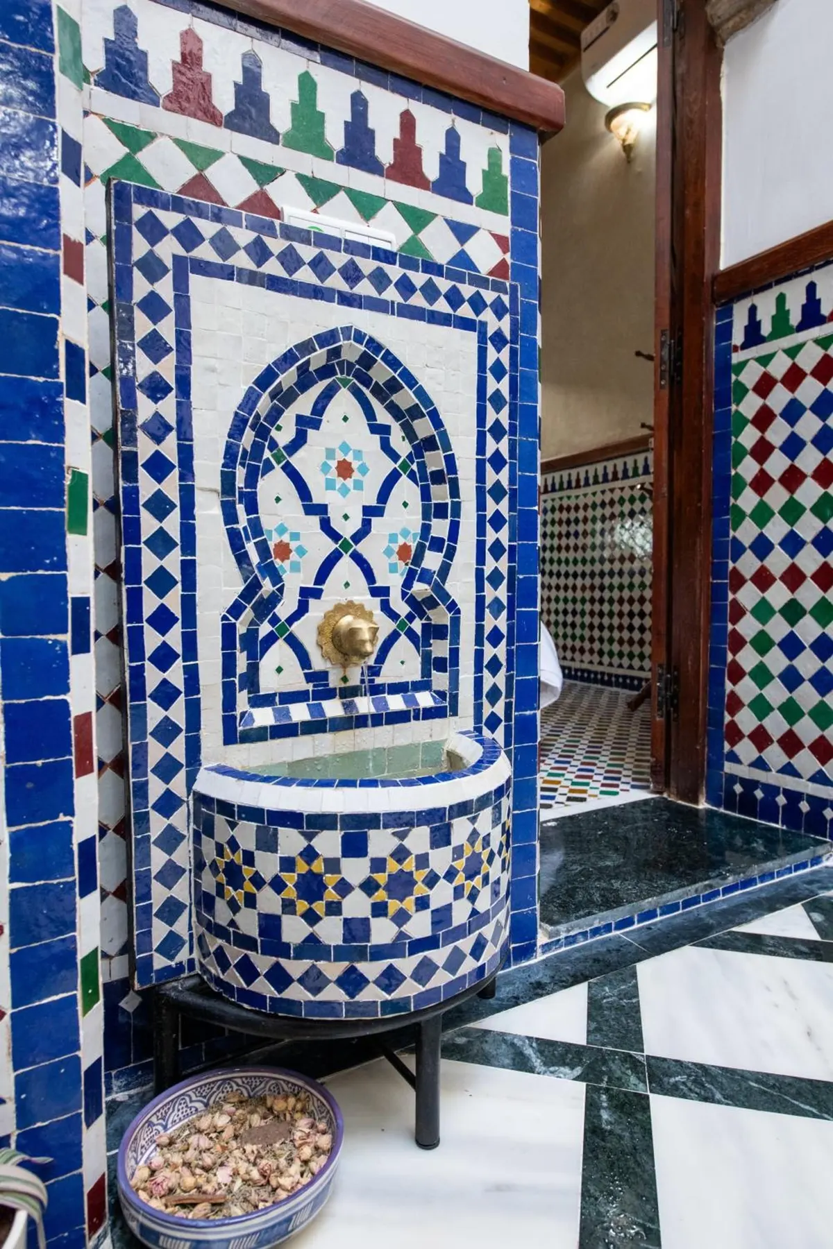 Blue-and-white zellige wall fountain in the patio