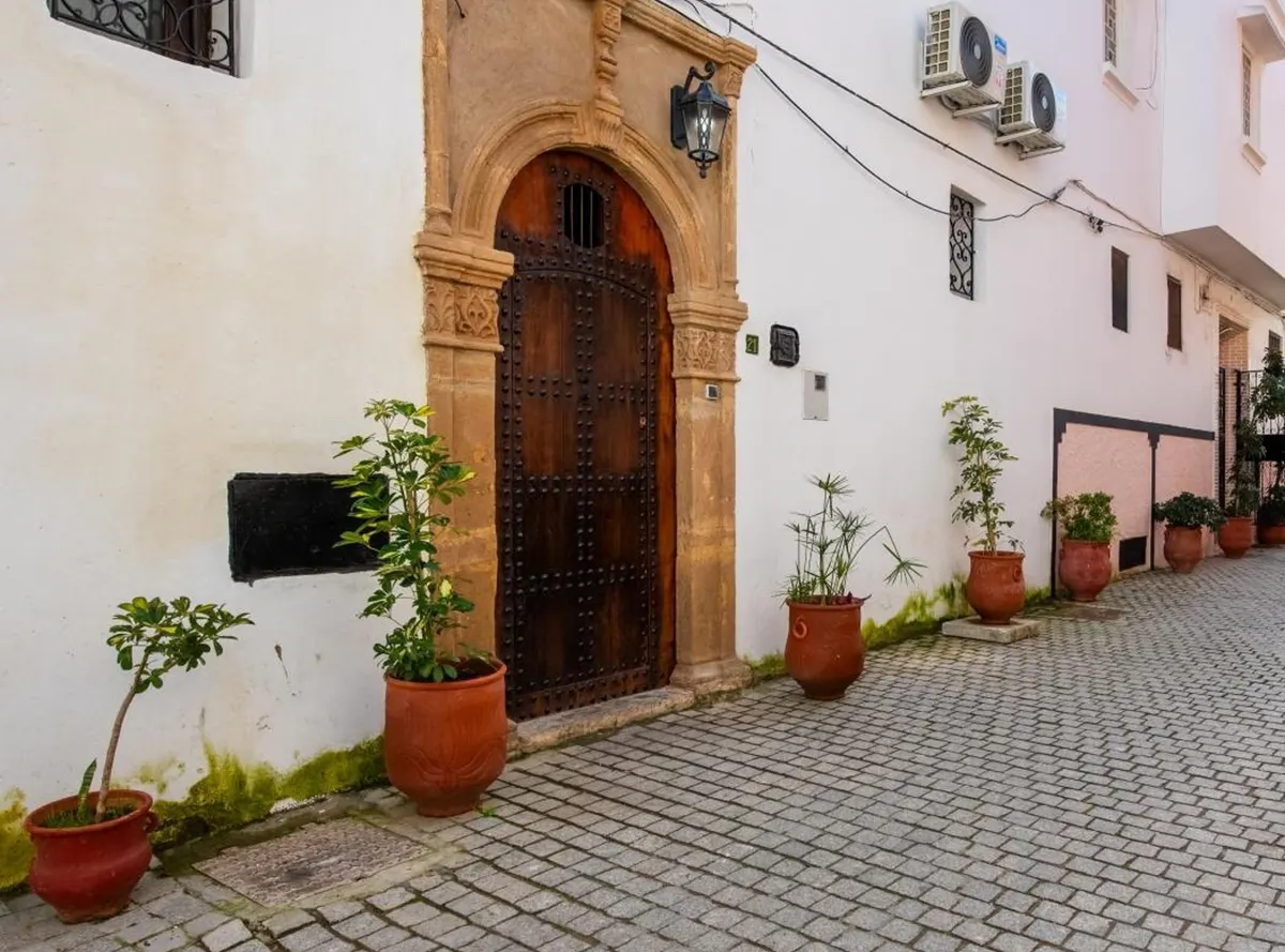 Rue Lalla Hannou: the ochre stone doorway of No. 21 and potted plants along the lane