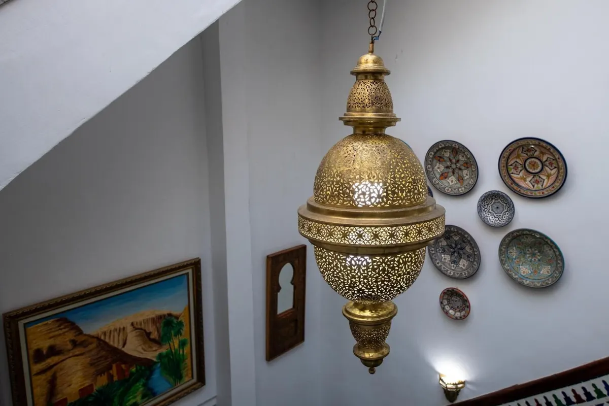 Brass lantern and decorative plates on a white wall