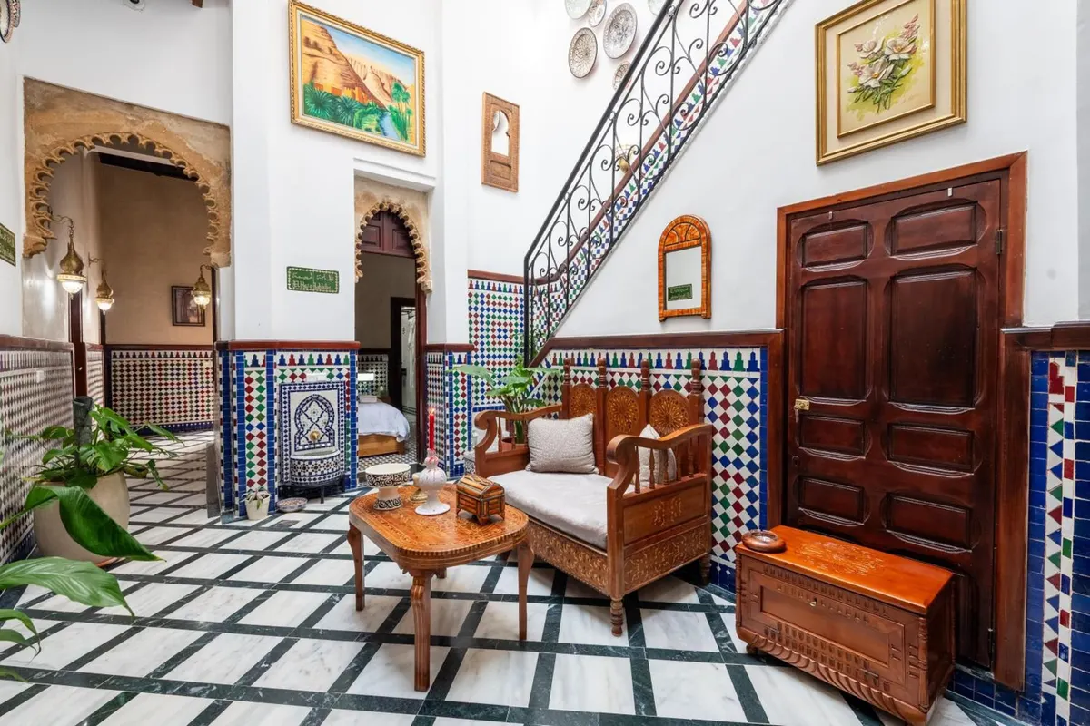 Patio corner with paintings, carved door and zellige stair