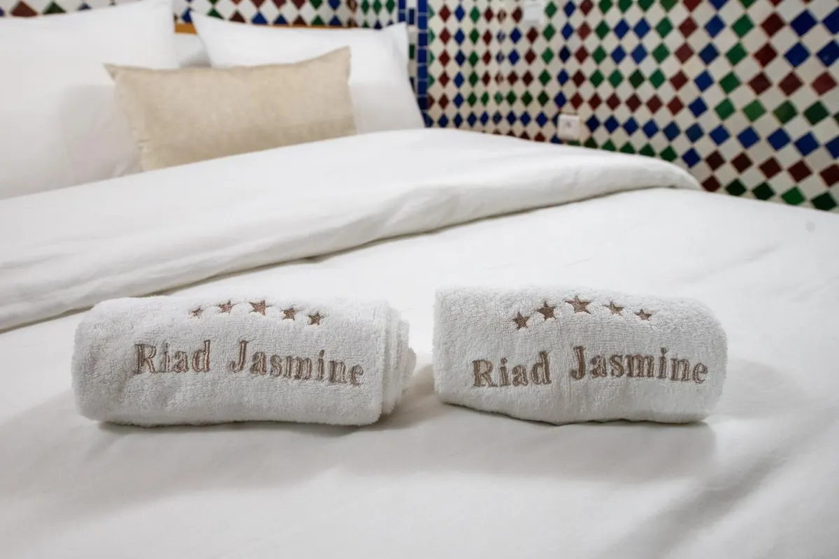 Rolled white towels embroidered with “Riad Jasmine”
