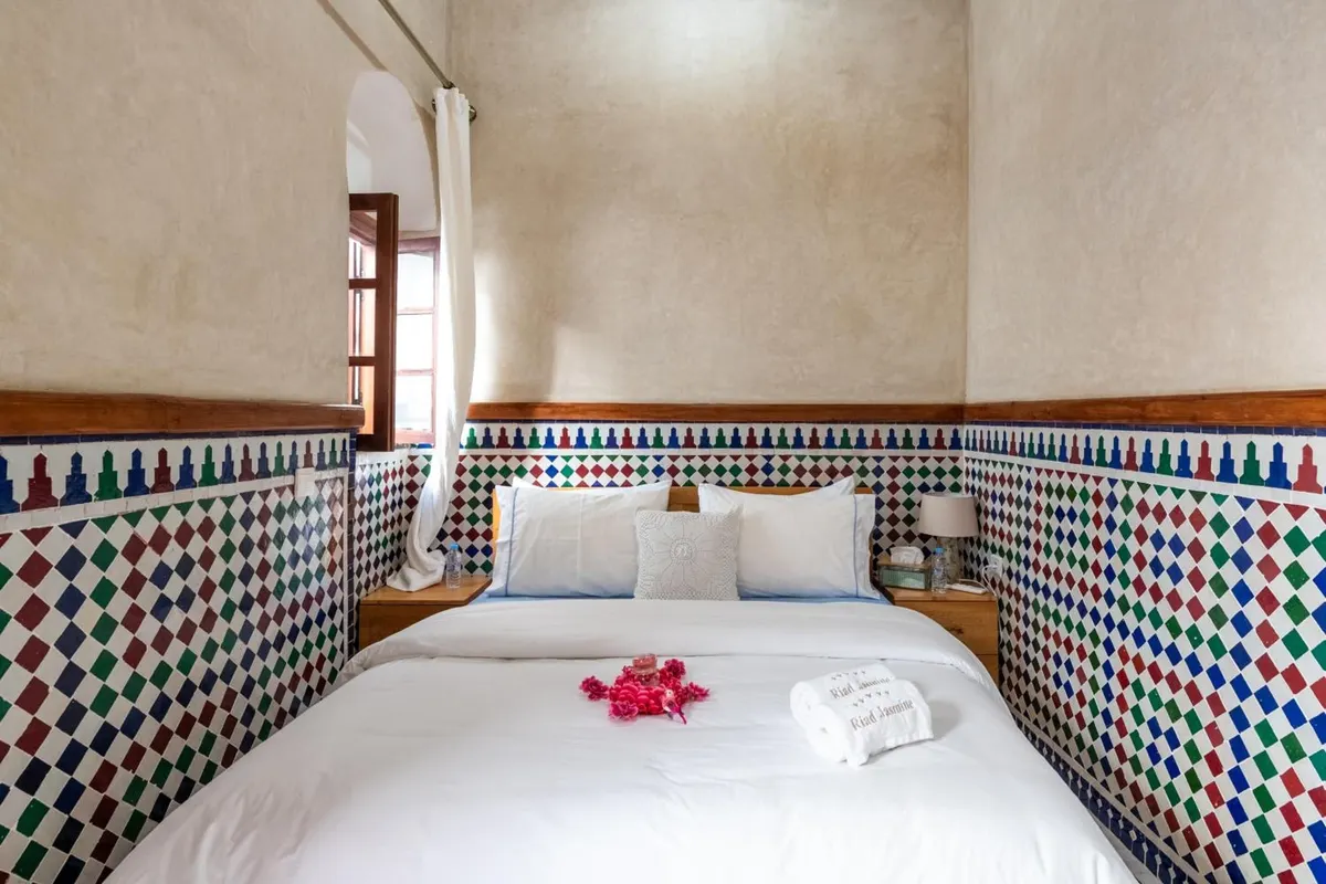 Double room bed with rose petals and embroidered towels