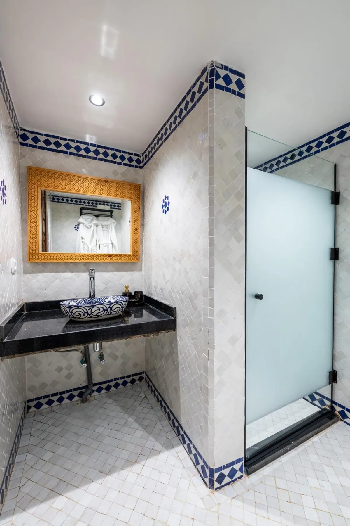 Glass shower with blue-and-white tile trim