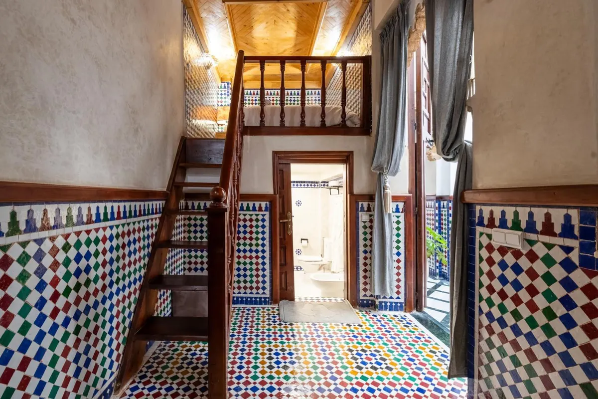 Wooden stairs up to the mezzanine, bathroom door below