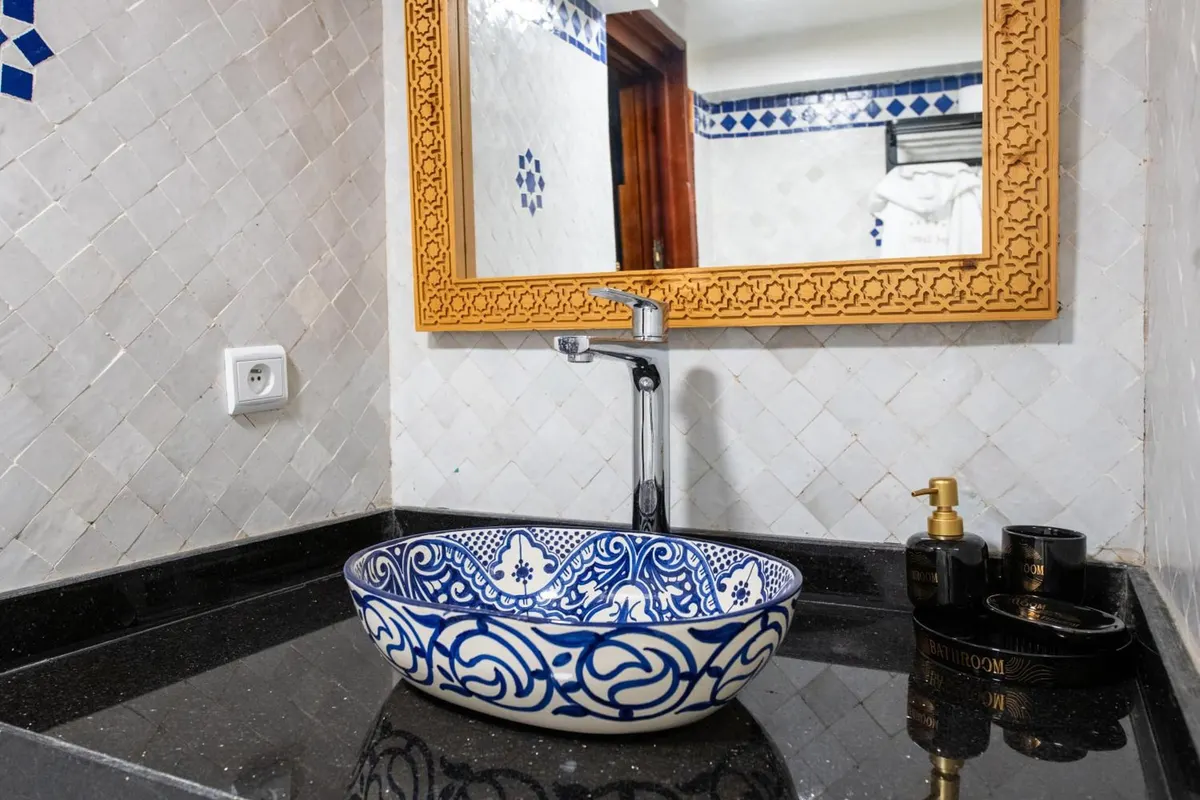 Blue-and-white hand-painted basin under a carved gilt mirror