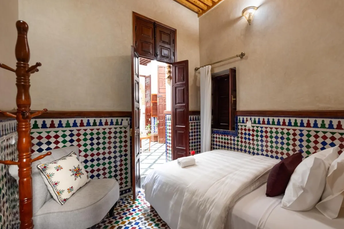 Single room with armchair, door open onto the patio